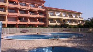Un hôtel à plusieurs étages doté de balcons, d’un espace piscine et d’une terrasse clôturée.