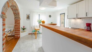 Una cocina moderna con armarios blancos, encimera de madera y un arco de ladrillo.