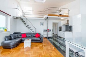 A modern apartment with a living room, kitchen, and a loft bedroom. - Holiday apartment near the beach (Funtana)