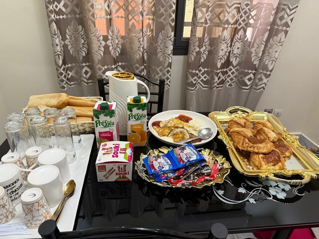 A breakfast tray with pastries, a coffee pot, and condiments.