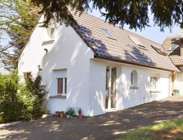 A white house with a sloped roof, a front door, and a small porch area. - Small house (Férolles-Attilly)