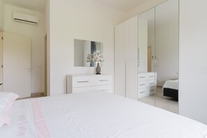 Un dormitorio con una cama, un aparador, un espejo y un armario.