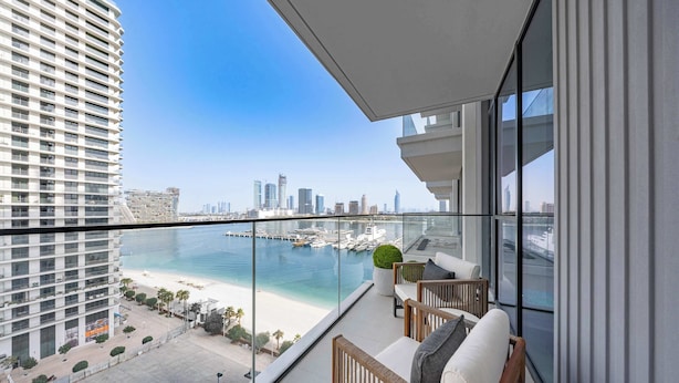 Un balcon offrant une vue sur un port de plaisance et sur les bâtiments de la ville.