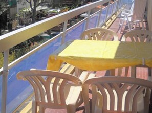 A balcony with a yellow table and white chairs, overlooking a marina with boats. - Beachside apartment with parking for 4 people (Argelès-sur-Mer)