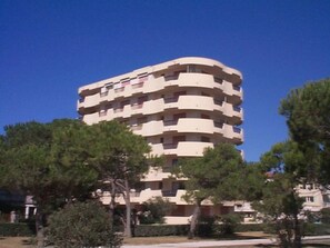 A multi-story residential building with balconies, surrounded by trees and greenery. - Charming Apartment for 4 with Parking, Near Beach (Argelès-sur-Mer)