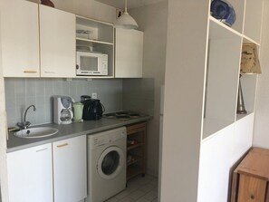 A compact kitchen with a sink, microwave, coffee maker, and a washing machine. - 6-Person Apartment at the Port with Private Parking (Argelès-sur-Mer)