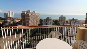 A balcony with a view of the sea, buildings, and a parking area. - Holiday apartment mit Pool und Meerblick (Lignano Sabbiadoro)
