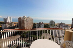 A balcony with a view of the sea, buildings, and a parking area. - Holiday apartment mit Pool und Meerblick (Lignano Sabbiadoro)