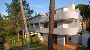 A modern two-story building with a flat roof, large windows, and a flat facade. - Holiday apartment mit Terrasse (Lignano Sabbiadoro)