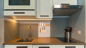 A modern kitchen with a stainless steel sink, a microwave, and a built-in oven. - Studio for 4 in Tignes, Pets allowed (Tignes)