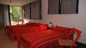 A room with three beds, a chair, and a desk with a lamp. - Holiday apartment mit Terrasse (Lignano Sabbiadoro)