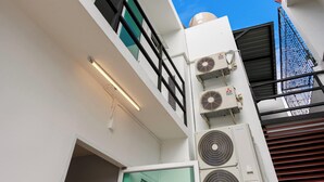 Een modern gebouw met een plat dak, grote airconditioningunits en een duidelijke deur.