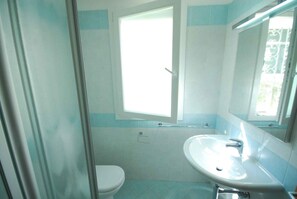 Une salle de bain avec des toilettes, un lavabo et une fenêtre.