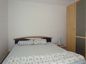 Ein Schlafzimmer mit einem Bett, einem Holzschrank und einem Nachttisch.