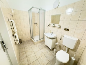 A modern bathroom with a glass-enclosed shower, a sink, toilet, and a mirror. - 2 Bedroom Apartments 18 Min to center (Vienna)
