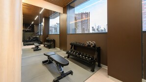 Ein Fitnessraum mit Trainingsgeräten, einer Bank und einer Hantelbank.