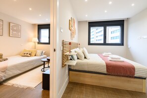 Ein modernes Schlafzimmer mit Bett, Nachttisch und Fenster.