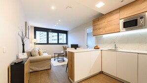 Eine moderne Küche mit Holzausstattung, einer eingebauten Mikrowelle und einem Fenster, das für natürliches Licht sorgt.