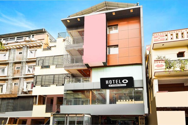 A multi-story hotel with a prominent 'HOTELO' sign, balconies, and a modern architectural design.