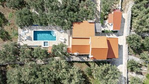 An aerial view of a property with a swimming pool, multiple buildings with tiled roofs, and surrounding vegetation. - Holiday Home Holiday Home Ivan with Heated Pool (Blato/Insel Korčula)