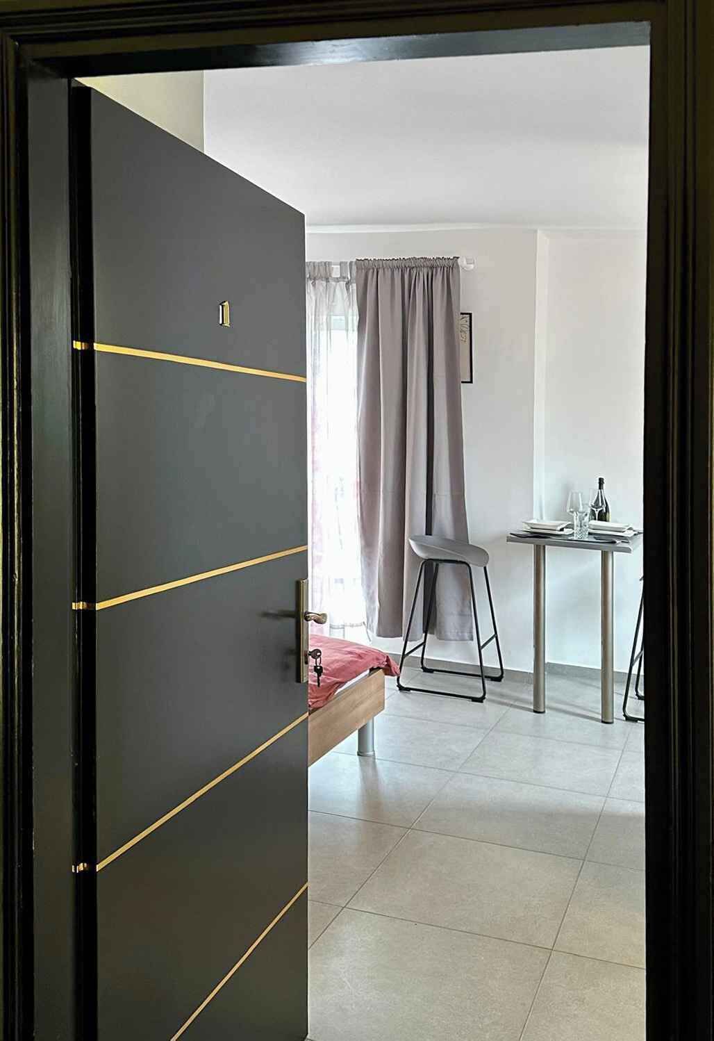 Una habitación con una cama, una mesa y una silla, y una cortina.