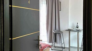 Ein Zimmer mit einem Bett, einem Tisch mit Stuhl und einem Vorhang.