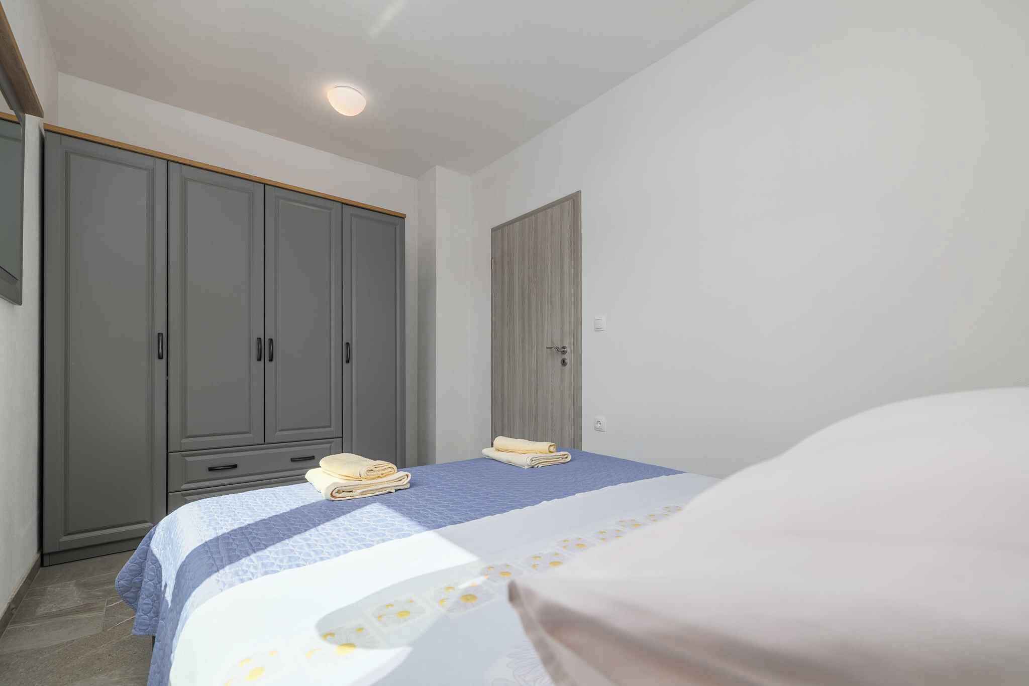 Et soveværelse med seng, garderobe og dør.