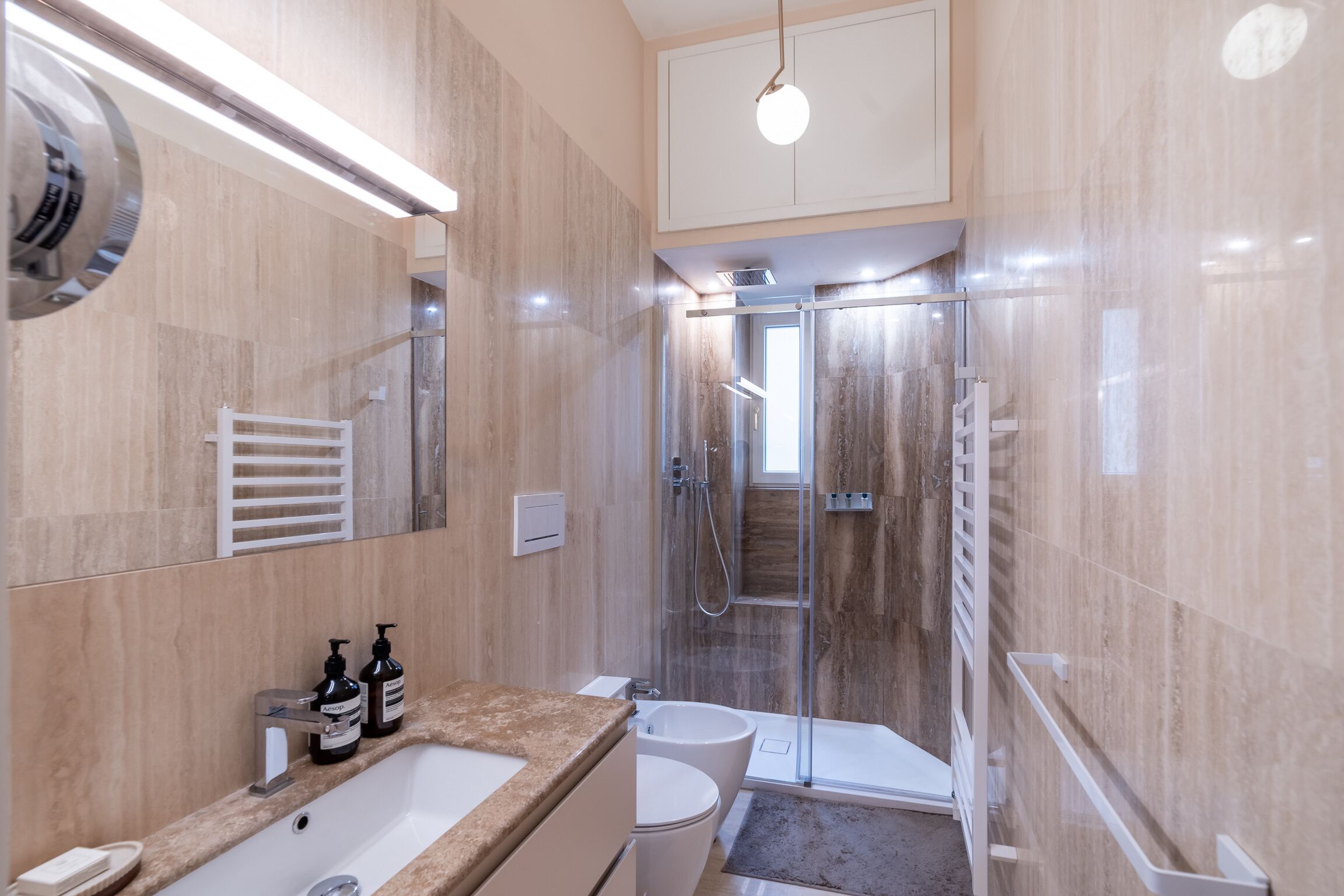 Une salle de bain moderne dotée d’une douche à parois de verre, d’une baignoire et de toilettes.