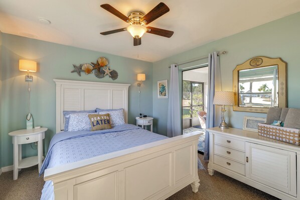 A bedroom with a bed, bedside tables, a dresser, a ceiling fan, and decorative items on the walls. - Sebring Fairway Villa Golf, Lake, Track, & Pools (Sebring)