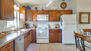 A kitchen with wooden cabinets, a white stove, a refrigerator, and a sink. - Sebring Fairway Villa Golf, Lake, Track, & Pools (Sebring)