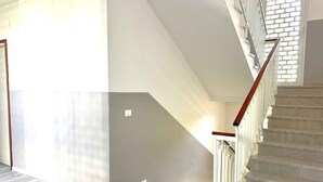 Un escalier avec une rampe en bois et un mur de couleur claire.