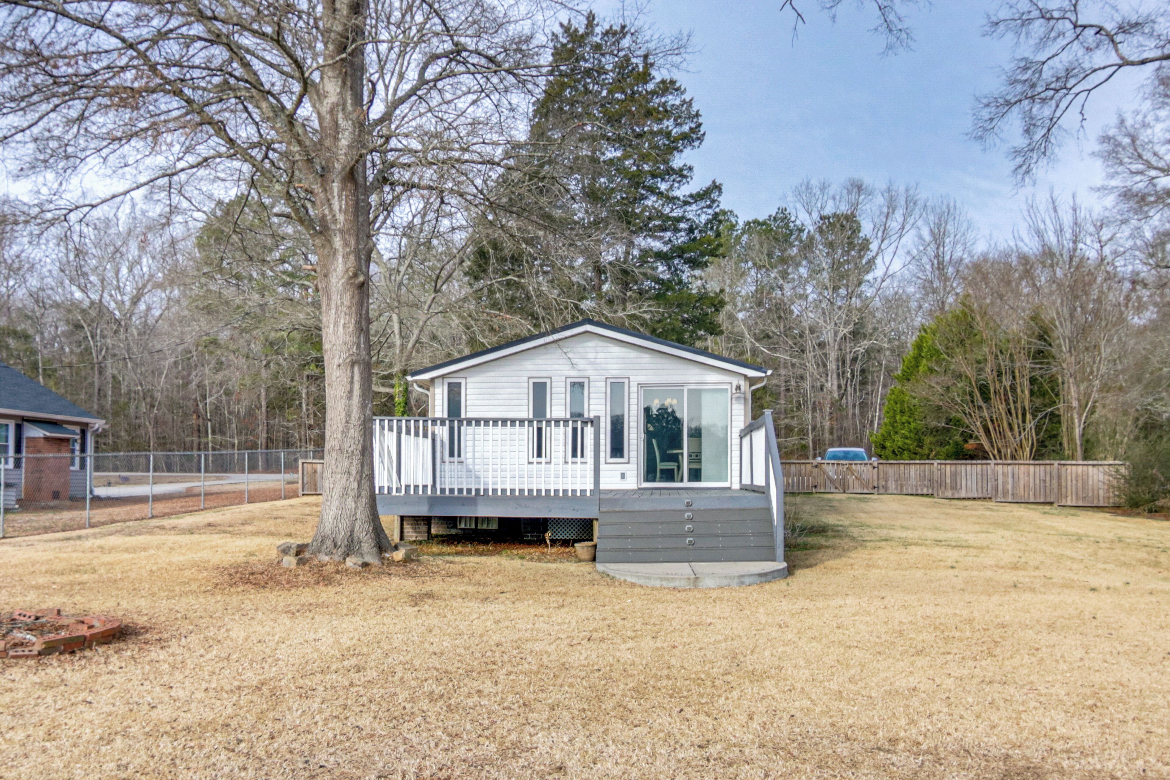 A single-story house with a front porch, a garage, and a fenced yard.