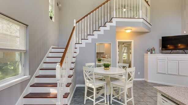 A staircase with white railings and wooden steps leading to a second floor. - < 1 Mi to St Johns River: Serene Family Home! (St. Augustine)