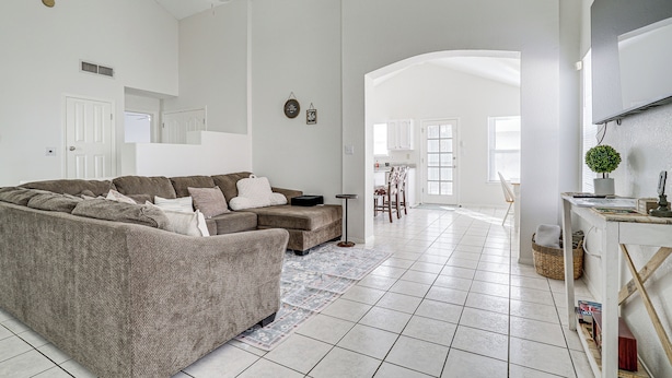 A spacious living room with a sectional sofa, a ceiling fan, and a dining area in the background. - Pool & Outdoor Space: Sunny El Paso Retreat! (El Paso)