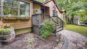 A house with a porch, a small staircase, and a flag. - Newly Renovated! Peaceful Saylorsburg Home (Saylorsburg)
