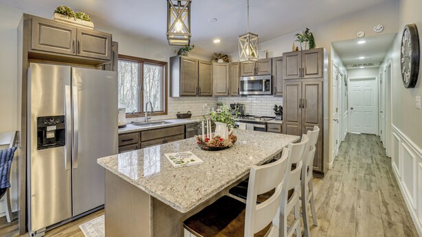 A modern kitchen with stainless steel appliances, granite countertops, and pendant lighting. - Newly Renovated! Peaceful Saylorsburg Home (Saylorsburg)