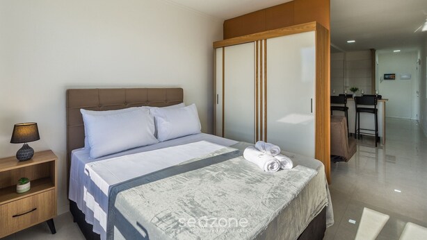 A hotel room with a bed, a nightstand, a desk, and a wardrobe. - Full Studio 700m From Bourbon Shopping Umb0604 (Porto Alegre)