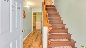 A staircase with patterned risers and a door with decorative text. - Pet Friendly & WFH Ready! Quiet Hudson Valley Apt (Newburgh)