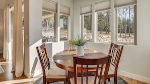A dining area with a round table, wooden chairs, and a potted plant. - Trail Access On-site! Wooded Colorado Springs Gem (Colorado Springs)