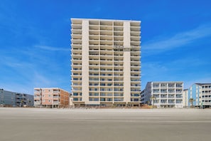 A multi-story hotel with balconies, a flat roof, and a sandy ground floor. - Great for Families! Murrells Inlet Beachfront Gem (Murrells Inlet)