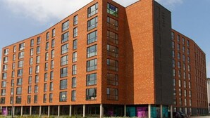 A modern multi-story building with a brick facade and large windows. - Cathedral Road by UTDM (Derby)
