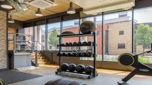 A gym with weightlifting equipment, a staircase, and large windows. - Cathedral Road by UTDM (Derby)