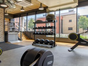 A gym with weightlifting equipment, a staircase, and large windows. - Cathedral Road by UTDM (Derby)