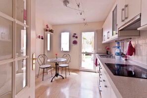A kitchen with a dining area, a sink, and a window.