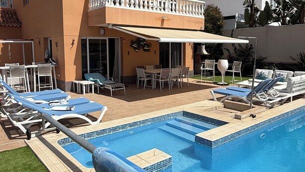 Un bâtiment à deux étages doté d’une piscine, d’un espace extérieur aménagé et d’une terrasse couverte.