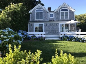 Une maison à deux étages dotée d’un patio couvert.