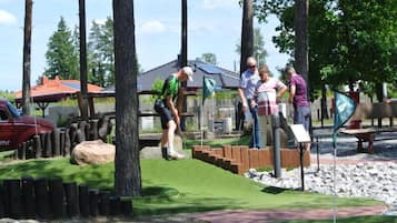 En golfbane med putting green, træhegn og et flag, der markerer hul 4.