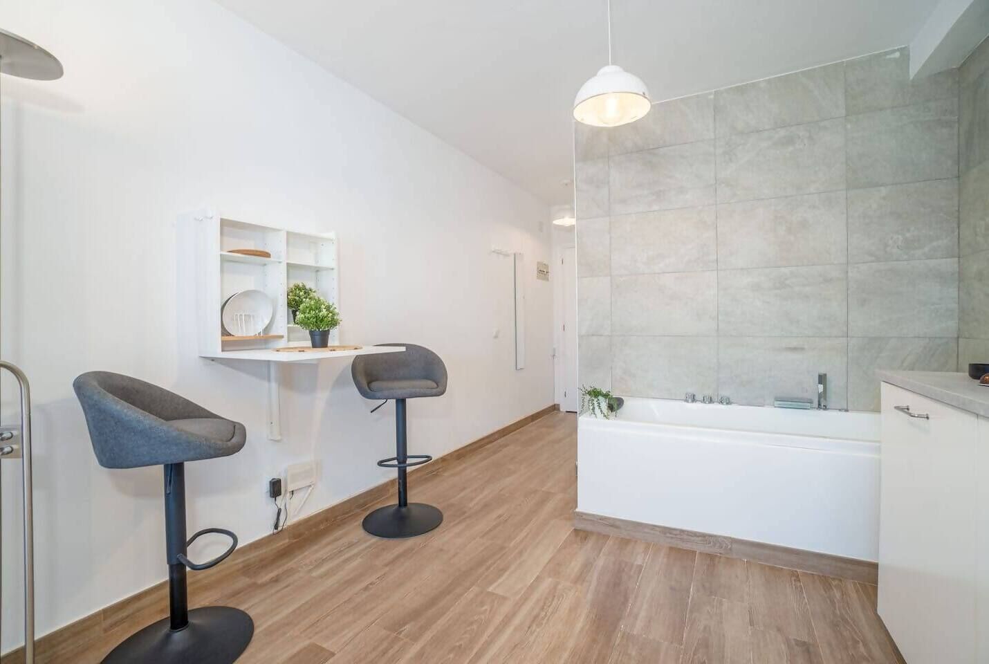 Une salle de bain moderne équipée d’une baignoire, d’un espace douche et de deux tabourets de bar.