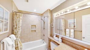 A bathroom with a bathtub, shower, vanity, and a large mirror with lights. - Oceanfront Wild Dunes Condo with Direct Beach Access & Unobstructed Views (Isle of Palms)