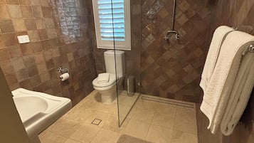 Een douche, handdoeken, zeep, toiletpapier